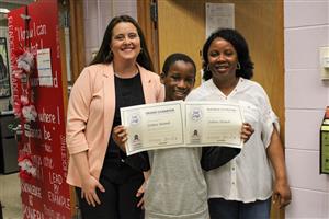 student holding two certificates
